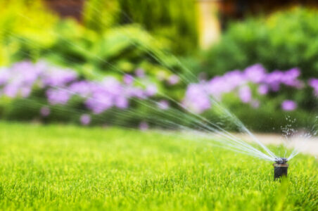 automatic sprinkler system watering the lawn on a background of automatic sprinkler system watering the lawn on a background of green grass, close-up